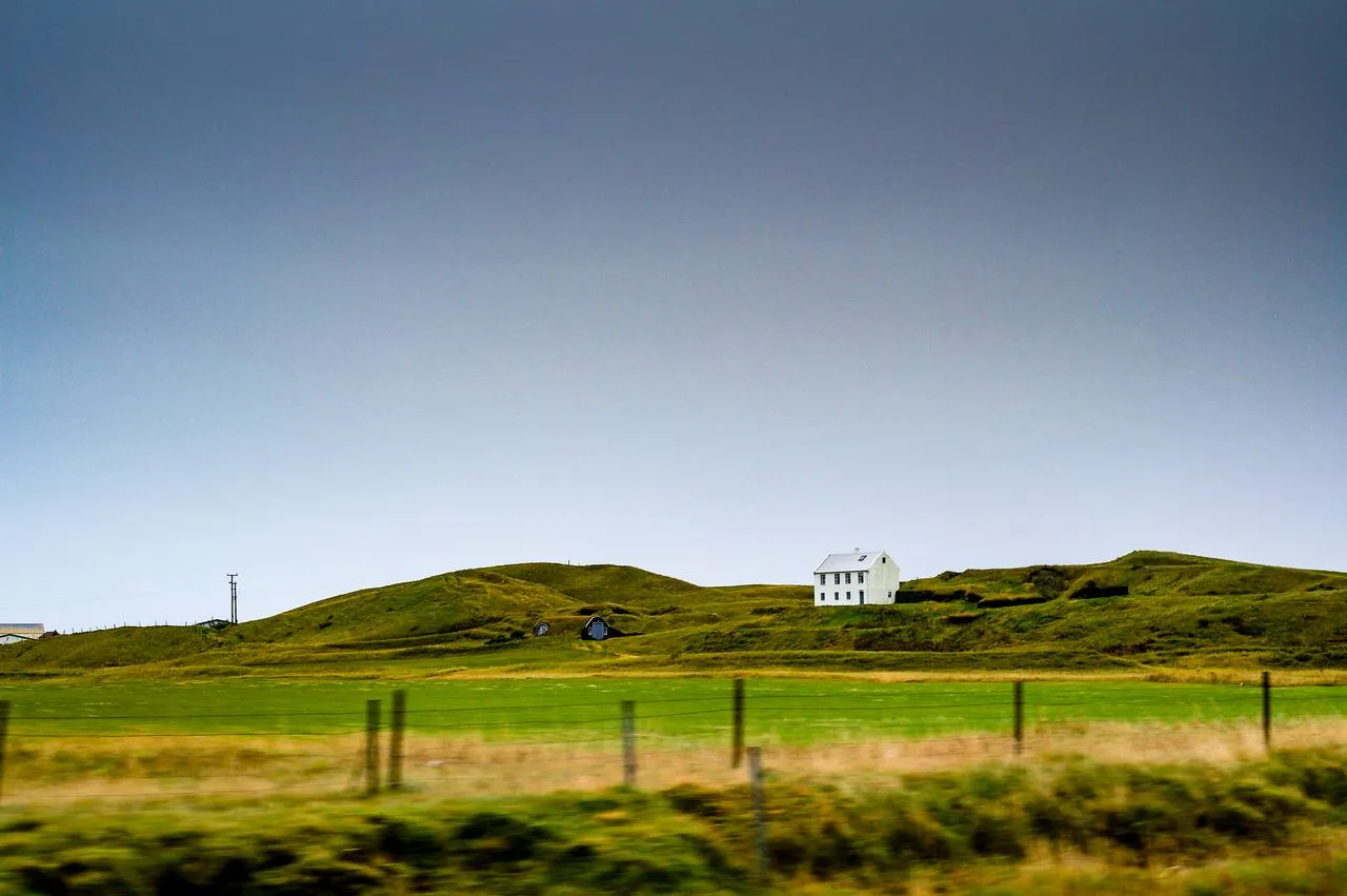 A single-family home on an open hill with a cleared perimeter